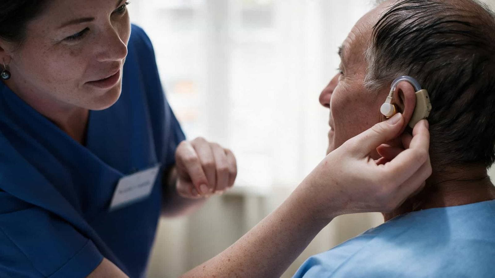 Audioprotesista che lavora sull'orecchio di una paziente